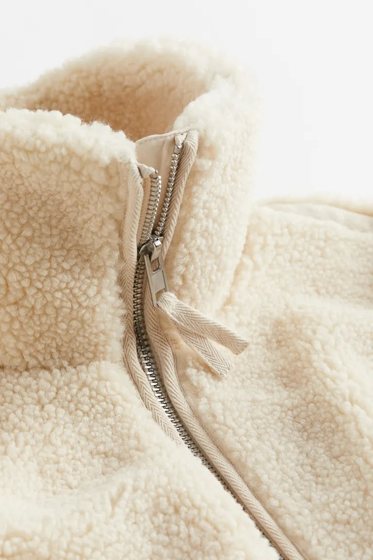Stylish women's zip-up winter jacket in a creamy white, designed for warmth and comfort in cold weather.
