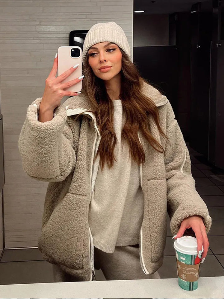 Stylish beige women's winter jacket with a full zip, offering cozy warmth and a relaxed fit for cold days.