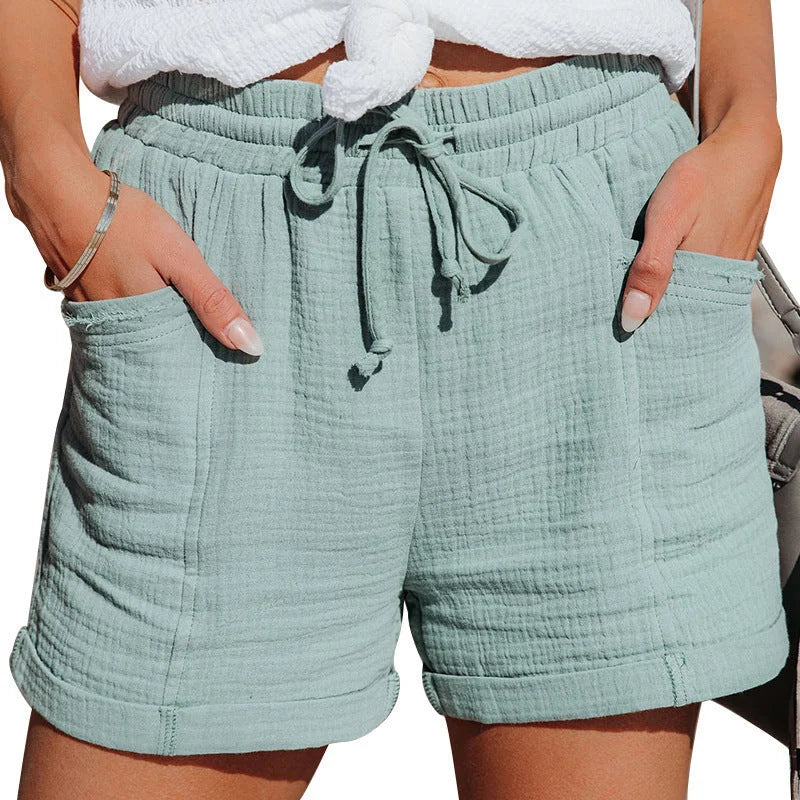 Women's relaxed fit crinkled shorts, drawstring waist, cuffed hem, pockets. Ideal for vacation style.