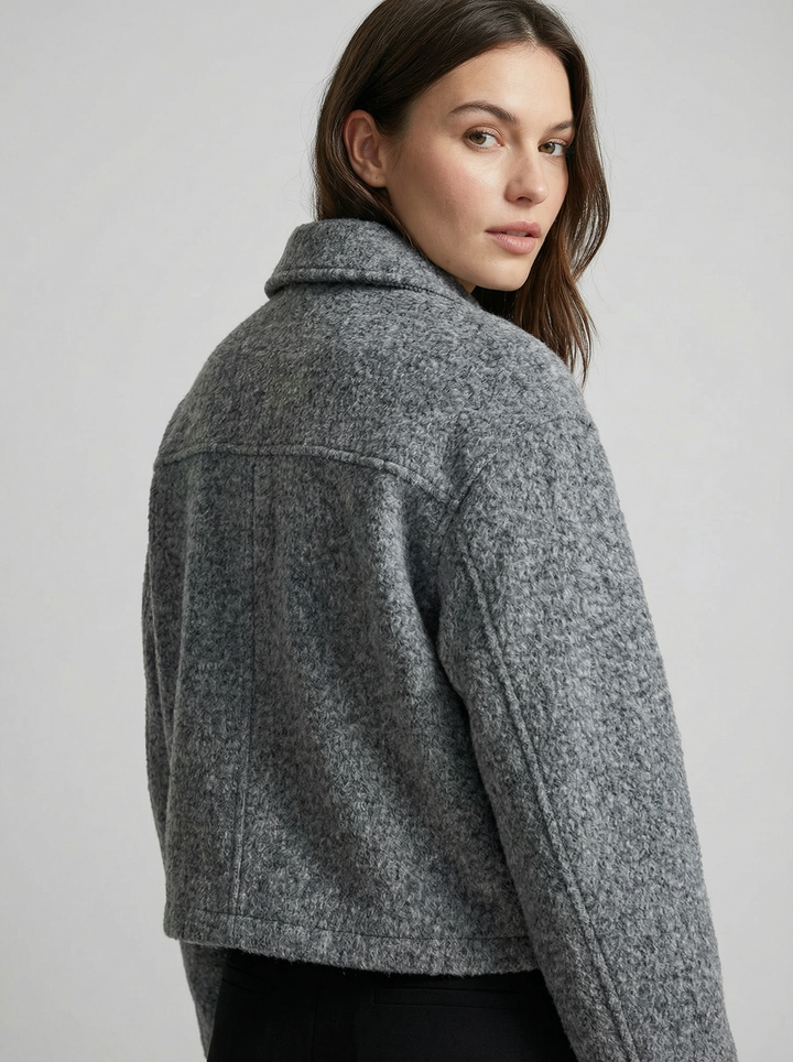 Modern women's gray cropped zip jacket, perfect for layering. Stylish casual outerwear with pockets.