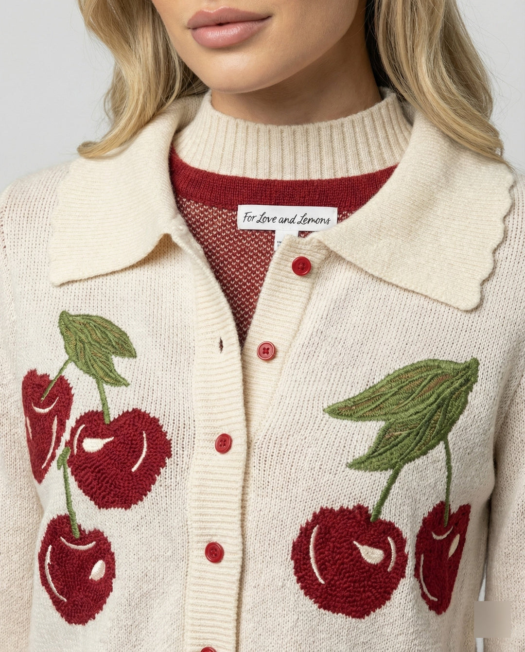 Close-up of the intricate cherry blossom floral pattern on a women's cropped knit jacket.
