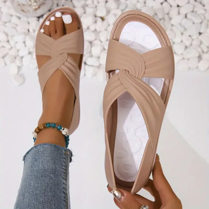 Comfortable women's slip-on sandals with cushioned footbed & unique crossover design. Ideal for summer.