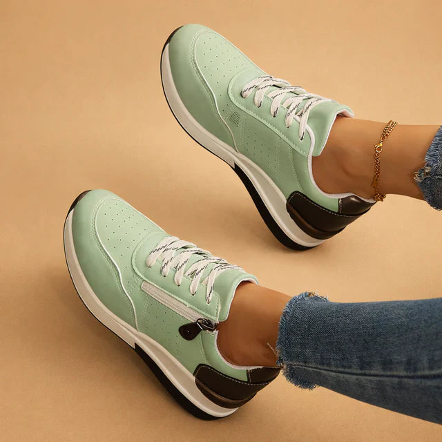 Low-top women's sneakers with cushioned sole & perforated upper for breathability and daily comfort.