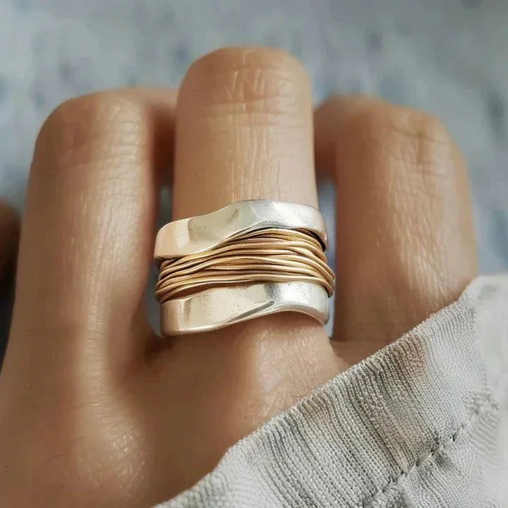 Women's dual-tone wavy metal ring with intricate wire-wrap detail. Fashionable statement accessory.