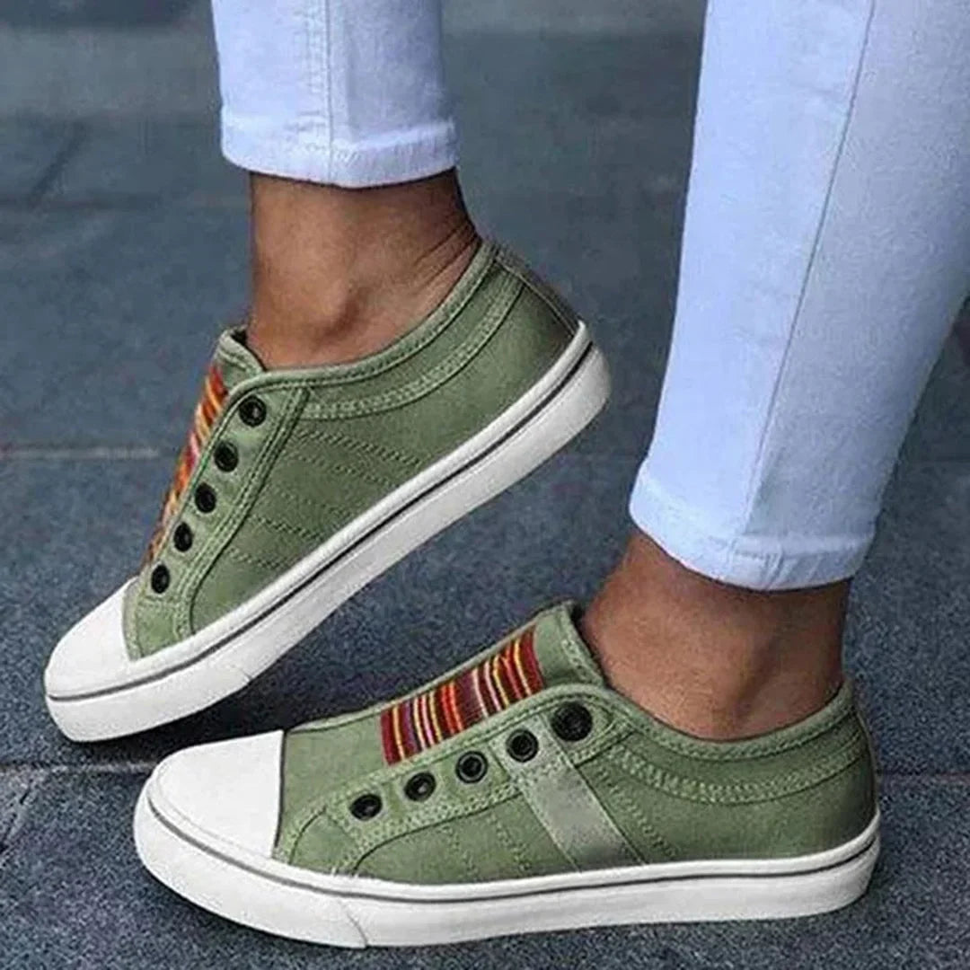 Stylish women's slip-on sneakers with striped pattern, faux laces, & comfortable design. Perfect for casual wear.