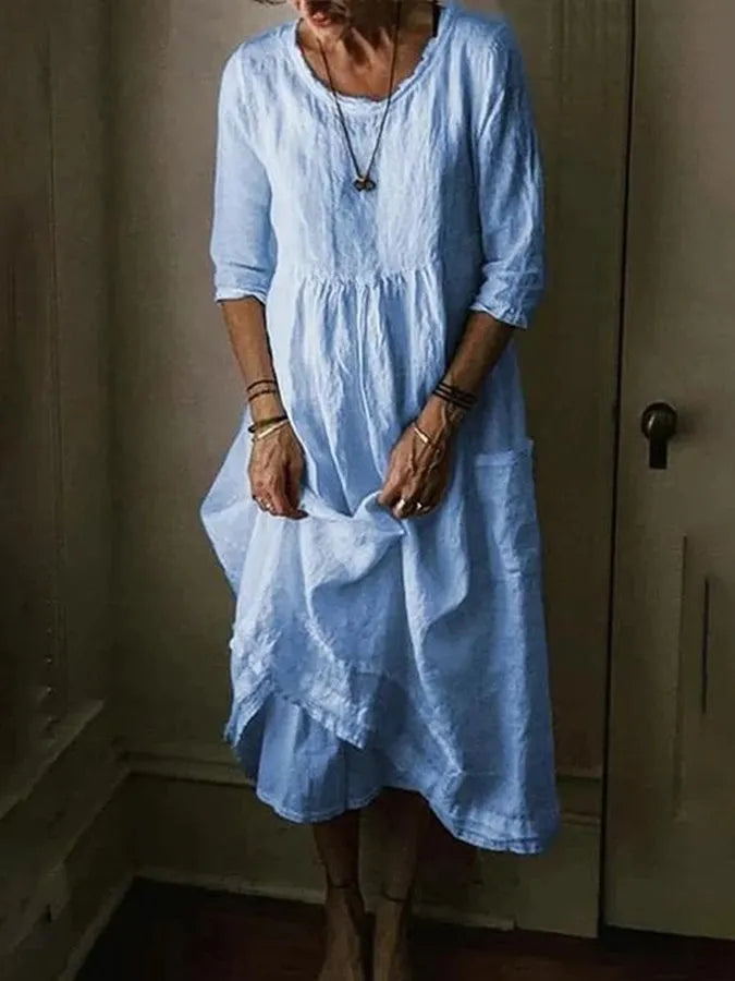 Women's effortless loose fit midi dress with 3/4 sleeves, pockets, and a stylish asymmetric hem for casual comfort.