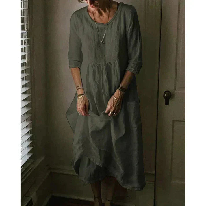 Comfortable women's midi dress; loose fit, 3/4 sleeves, pockets, and an elegant asymmetric hem for casual wear.