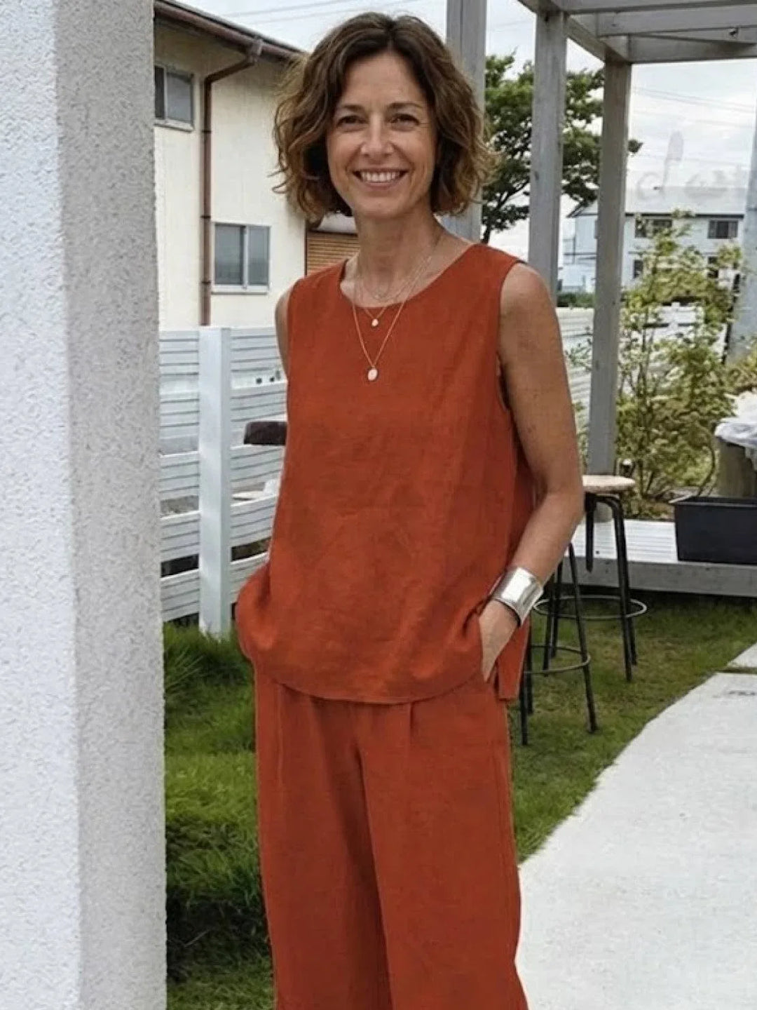 Woman sitting comfortably in a two-piece sleeveless top & wide-leg pants set, relaxed fit, perfect for summer.