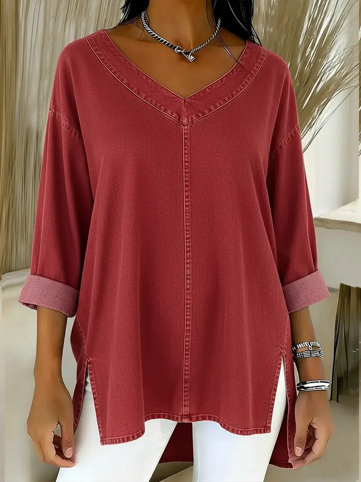 Woman wearing a relaxed v-neck denim shirt, long sleeve, styled casually. Effortless blue denim top for everyday fashion.