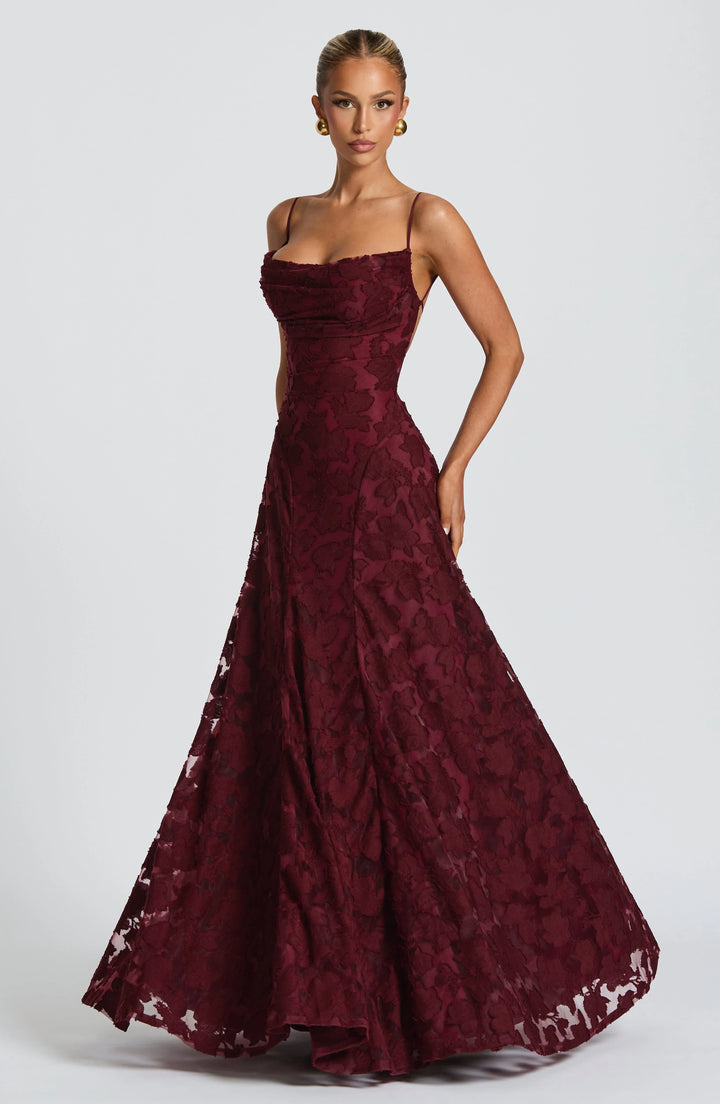 Model wearing a formal backless spaghetti strap maxi dress at a wedding