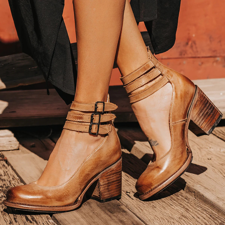 Women's elegant black ankle strap block heel boots, perfect for parties and dress occasions.