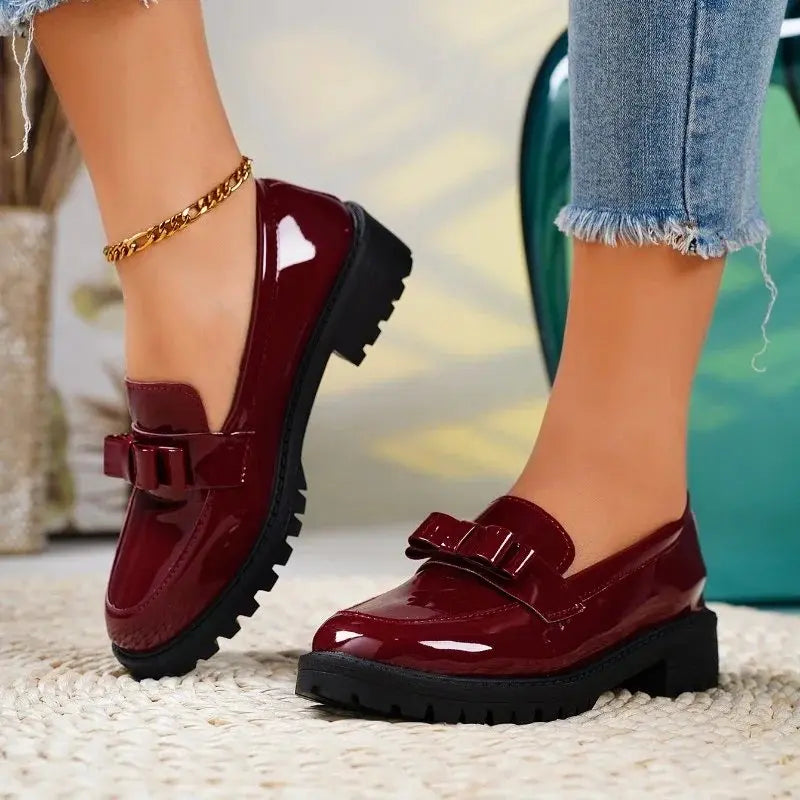 Women's elegant black patent leather orthopedic loafers with bow detail & chunky sole for all-day comfort.