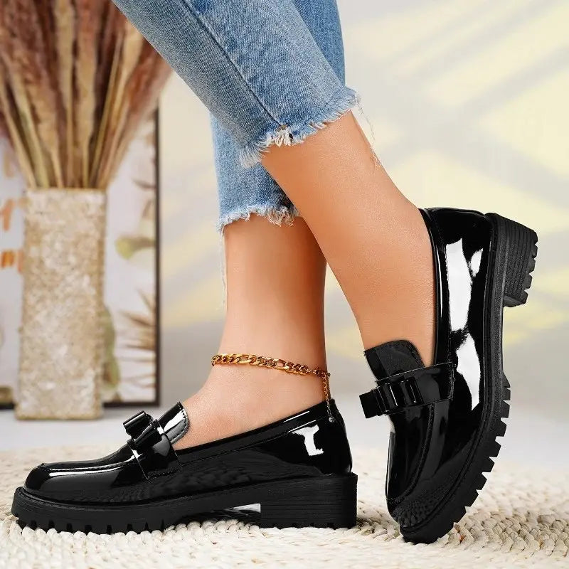 Fashionable black patent orthopedic loafers for women, perfect for work or casual wear, with a chunky lug sole.