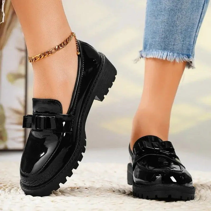 Women's slip-on comfort loafers, black patent leather with a stylish bow, chunky sole, and orthopedic support.