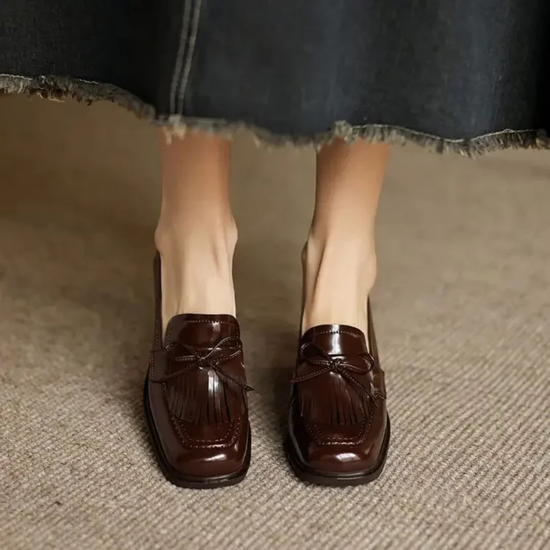 Womens classic black loafer pumps, designed with stylish tassels, a comfortable block heel, and a round toe.