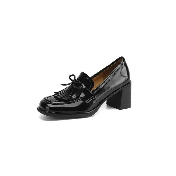 Stylish brown women's loafer pumps, featuring decorative tassels, a stable block heel, and a comfy round toe.