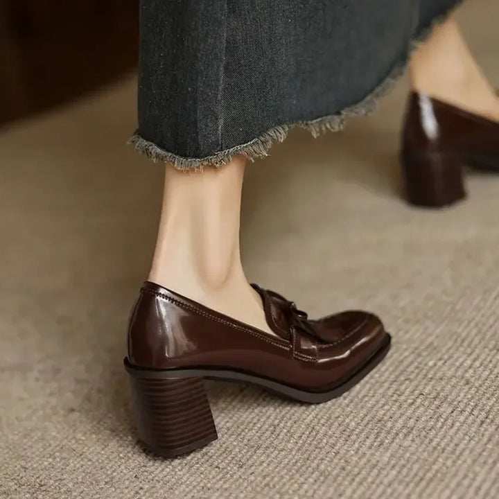 Chic brown women's block heel pumps with elegant tassels & a comfortable round toe, suitable for office wear.