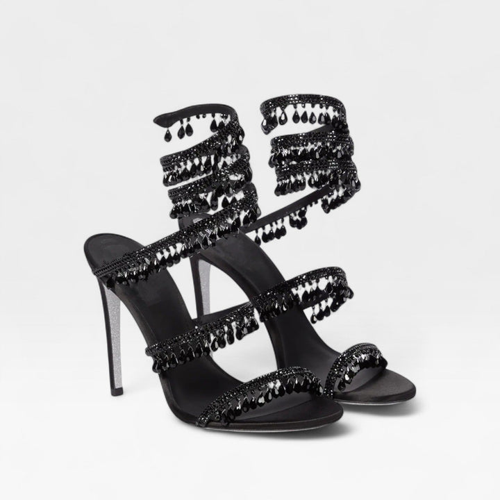 Close-up of crystal embellished straps on women's elegant high heel evening sandals.