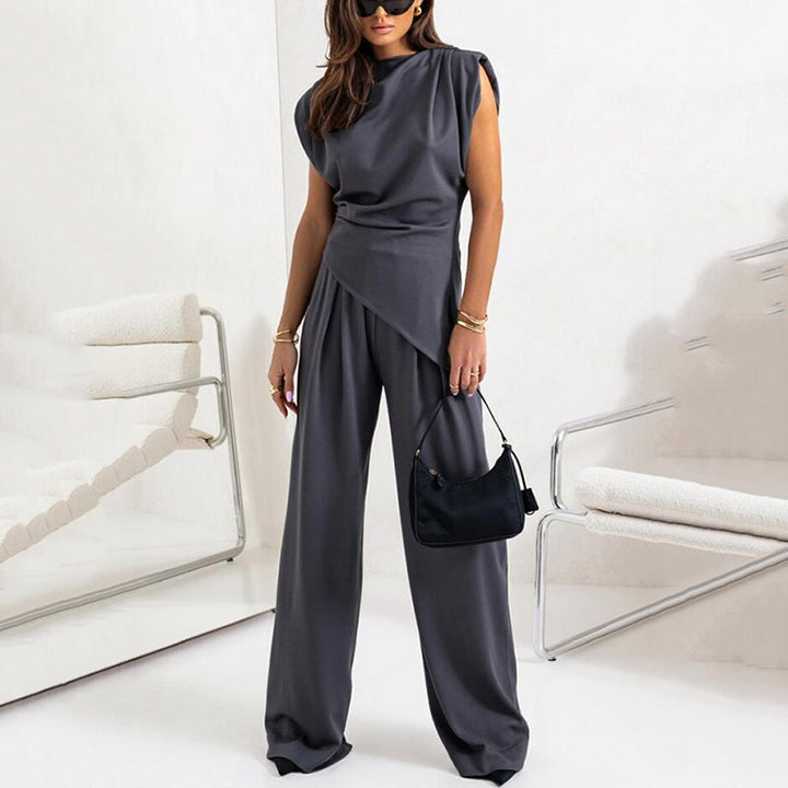 Full length view of women's two-piece set, featuring a sleeveless draped top and wide-leg trousers.