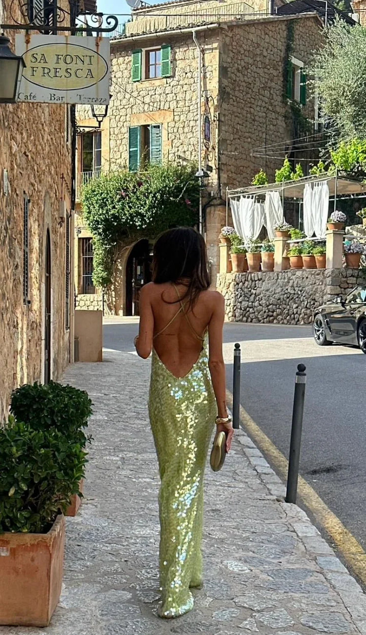 Women's luxurious emerald sequin backless evening gown. A glamorous maxi dress for parties and special occasions.