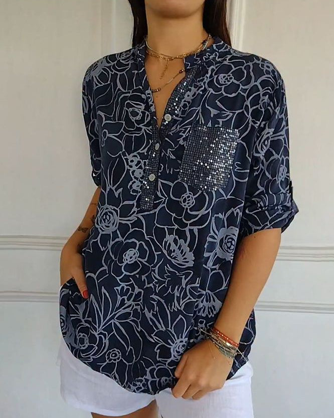 Stylish women's elegant blouse with vibrant floral pattern & functional front pocket. Relaxed fit top.