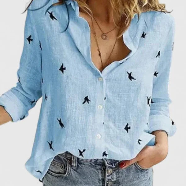 Close-up of floral pattern on women's V-neck long sleeve blouse, relaxed fit, showing fabric and buttons.