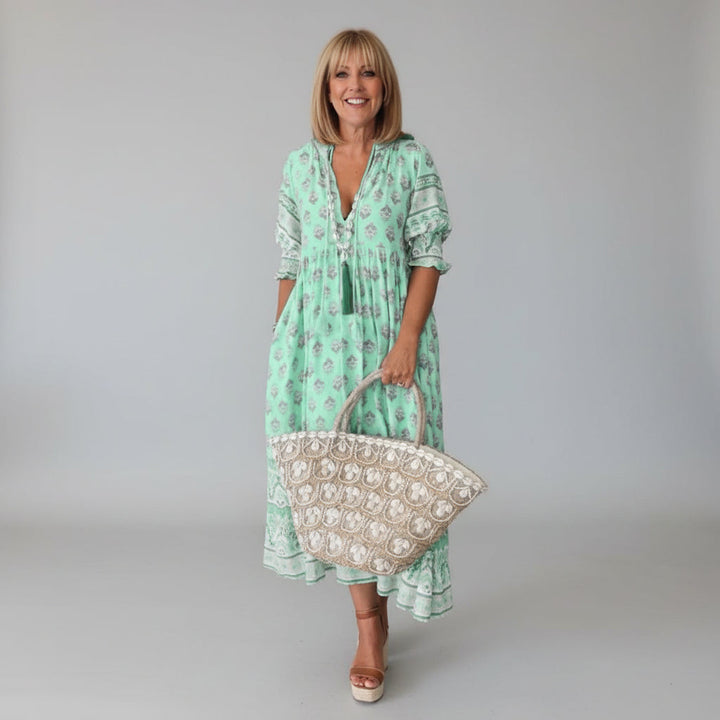 Women's elegant flowy midi dress in vibrant floral print, perfect for summer.
