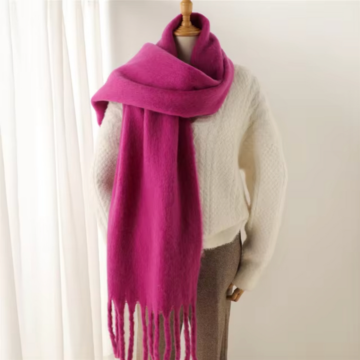 Stylish woman wearing a warm, cozy fringe scarf in a winter fashion setting.