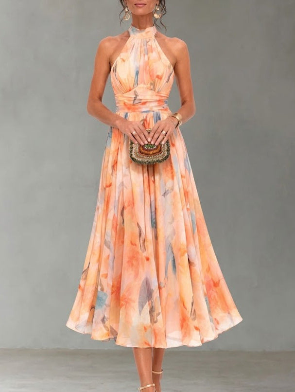 Women's elegant halterneck maxi dress with a vibrant watercolour print, perfect for summer. Flowy and lightweight.