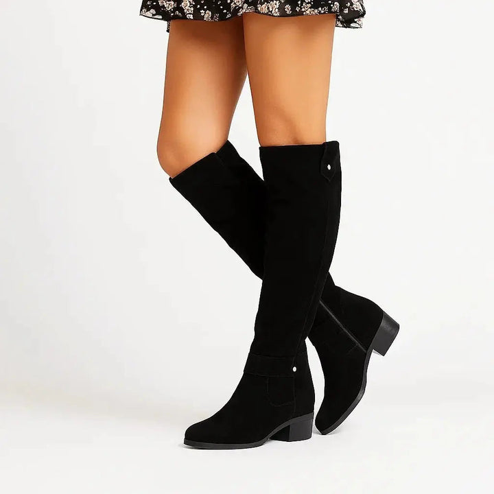 Stylish women's black suede knee-high boots featuring an elegant block heel, perfect for versatile fall outfits.