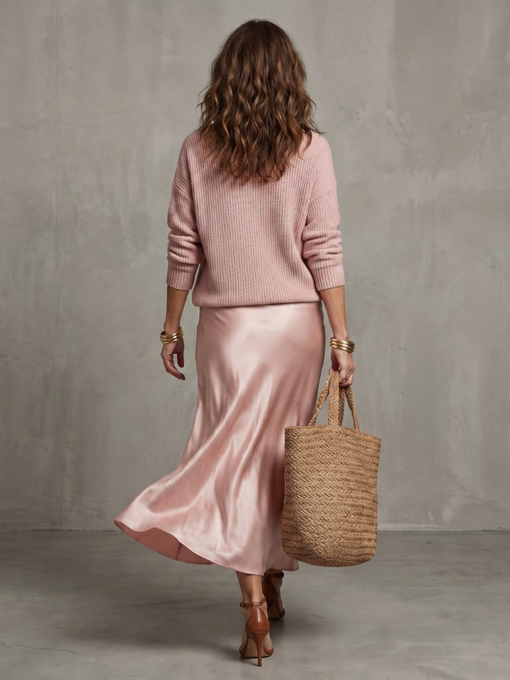 Chic women's fall fashion: long-sleeve layered top and elegant bias-cut midi skirt ensemble.