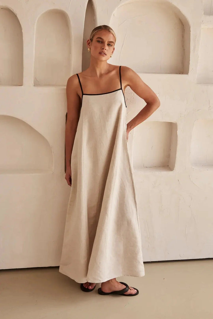 Flowy trapeze maxi beach dress for women, featuring chic contrast trim and comfy adjustable straps. Resortwear essential.