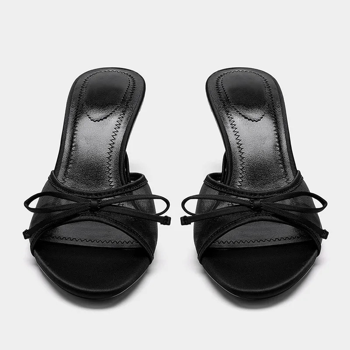 Chic side profile of women's open toe kitten heel mule sandals. Stylish animal print, comfortable slip-ons.