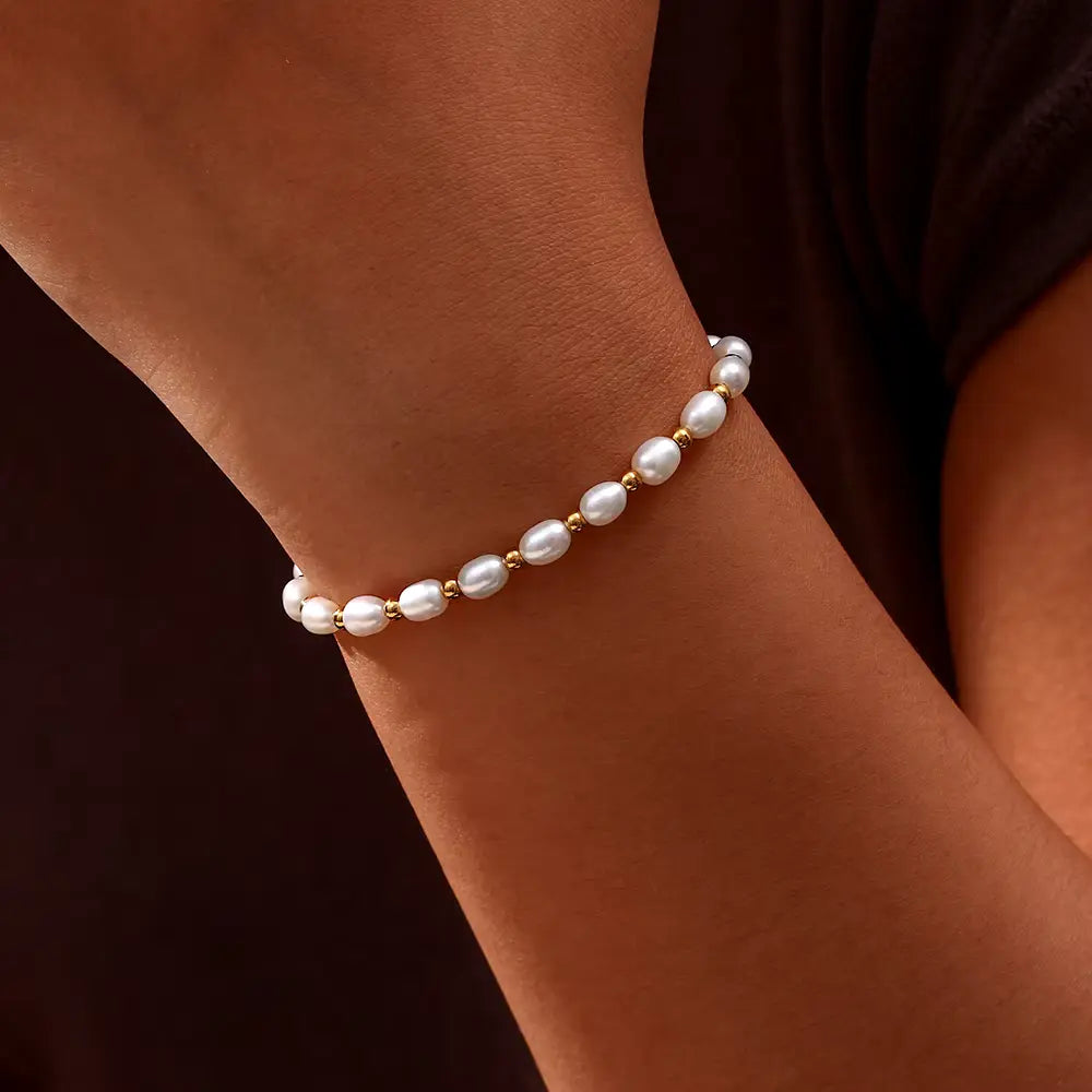 Classic women's gold bracelet with lustrous pearls, ideal elegant wrist jewelry for special occasions.