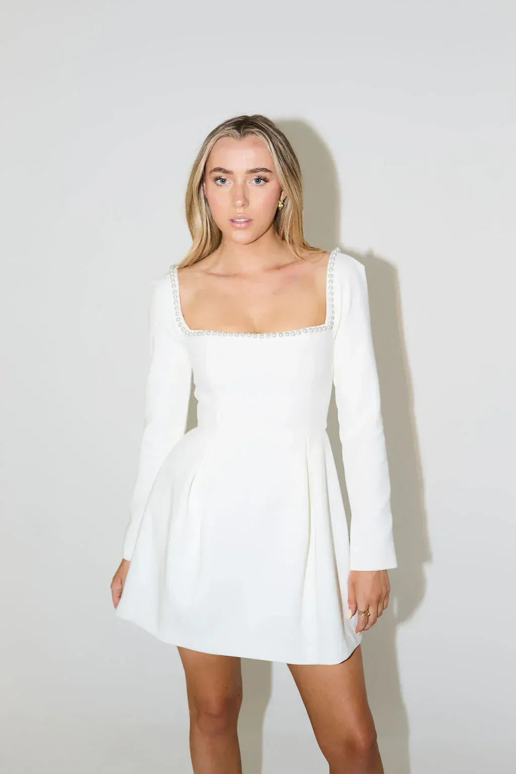 Sophisticated women's long sleeve mini dress with elegant pearl trim, a must-have for cocktail & evening wear.