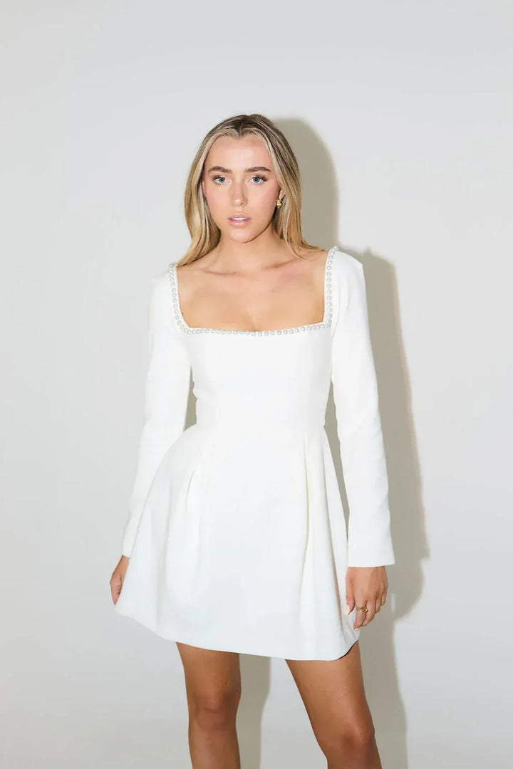Sophisticated women's long sleeve mini dress with elegant pearl trim, a must-have for cocktail & evening wear.