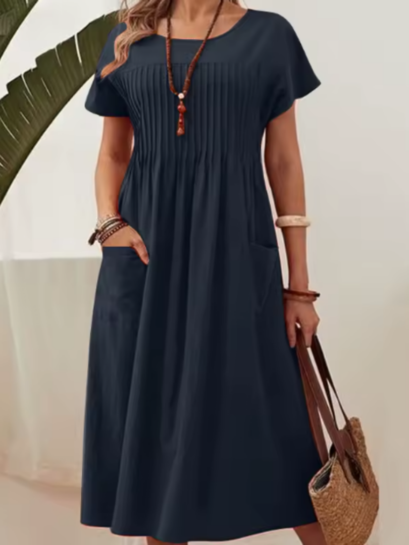 Relaxed fit women's midi dress featuring a stylish pleated bodice, short sleeves, and practical side pockets for elegance.