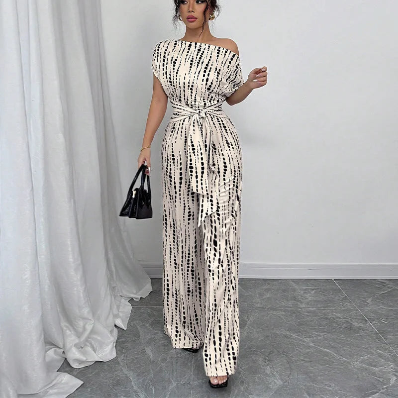 Fashionable women's belted jumpsuit featuring a chic one-shoulder and wide-leg design with a vibrant print.