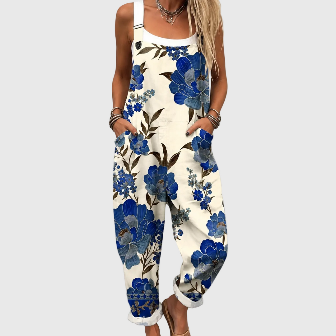 Women's elegant royal blue floral dungaree jumpsuit. Stylish, comfortable summer outfit for casual wear or vacation.