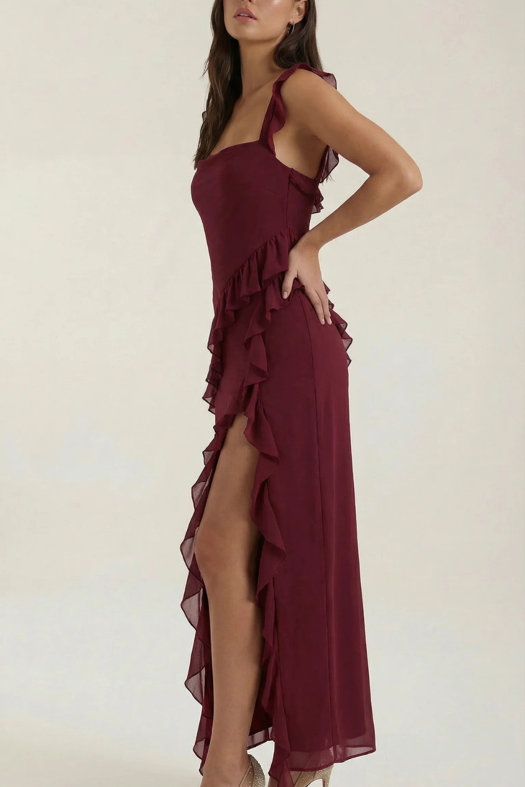 Sleeveless women's party dress, knee-length, with a fashionable ruffle and an alluring leg slit.