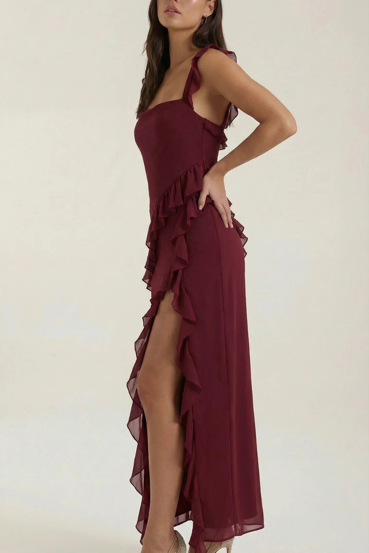 Sleeveless women's party dress, knee-length, with a fashionable ruffle and an alluring leg slit.