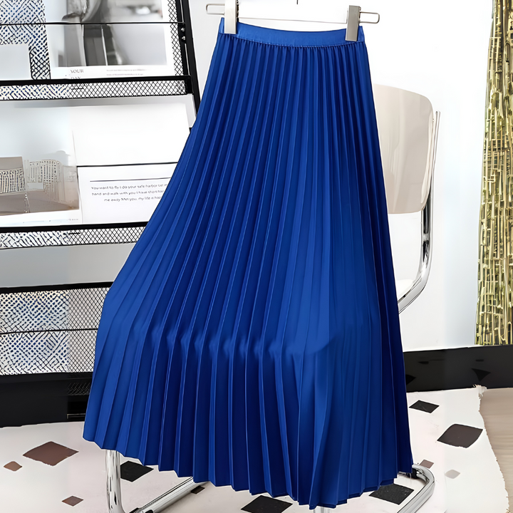 A woman modeling a chic, high-waisted satin pleated midi skirt.