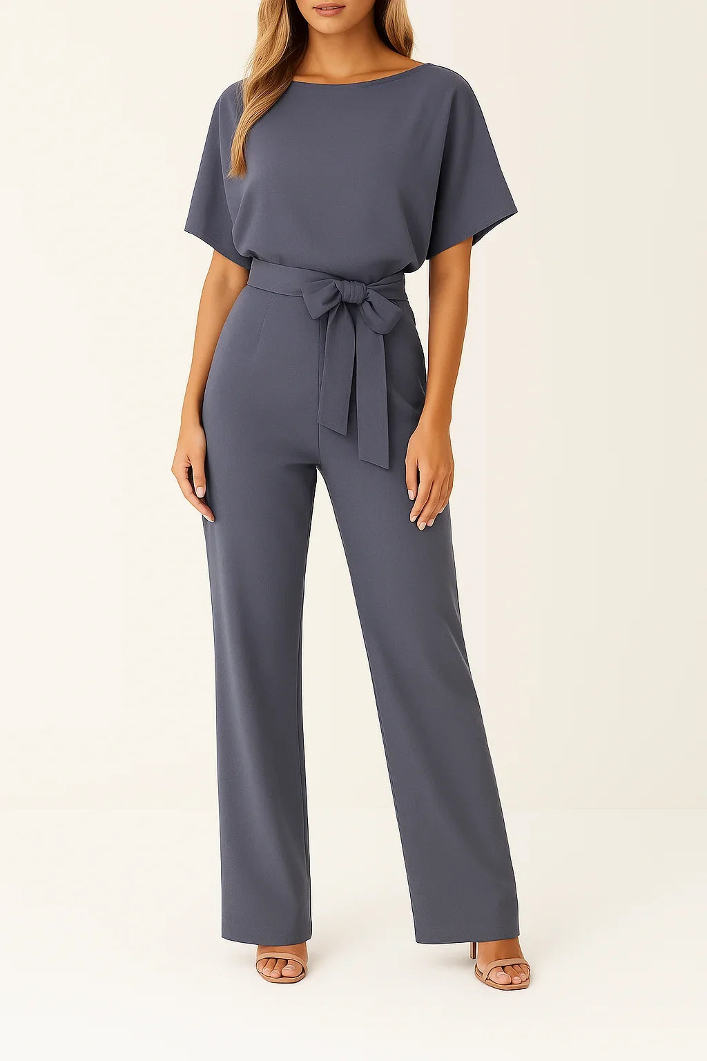 Model wearing a stylish women's short sleeve wide leg jumpsuit with a cinching tie waist. Summer fashion.