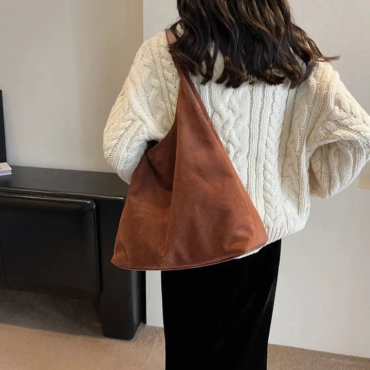 Minimalist women's suede shoulder bag, a versatile everyday luxury accessory.