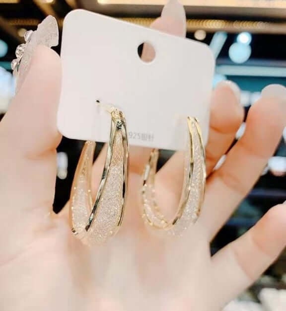 Elegant women's twisted oval hoop earrings, adorned with shimmering crystals, for any occasion.