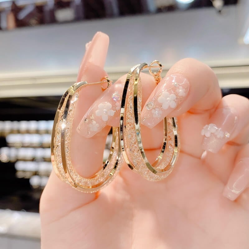 Crystal-embellished twisted oval hoops for women, a chic and modern accessory statement.