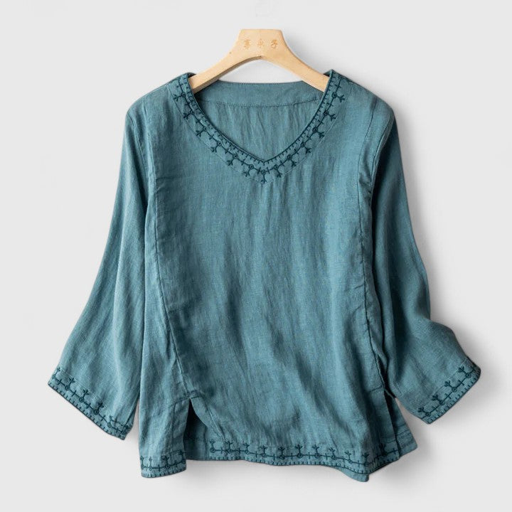 Women's elegant V-neck blouse with intricate floral embroidery. Stylish short-sleeve top for spring and summer chic.