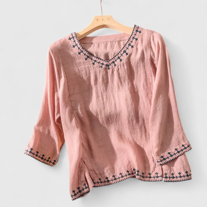 Embroidered V-neck women's blouse, featuring intricate details & a comfortable fit. Versatile short-sleeve top for summer fashion.