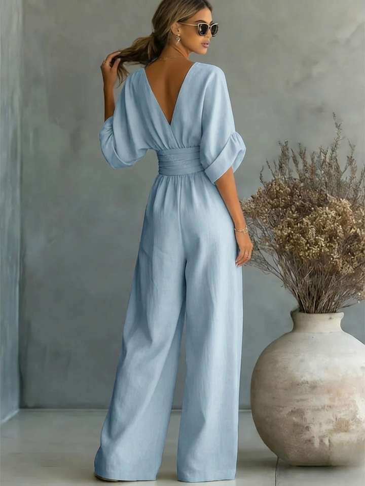 Model wearing a flattering women's elegant V-neck jumpsuit. Perfect for work, smart casual, or evening wear.