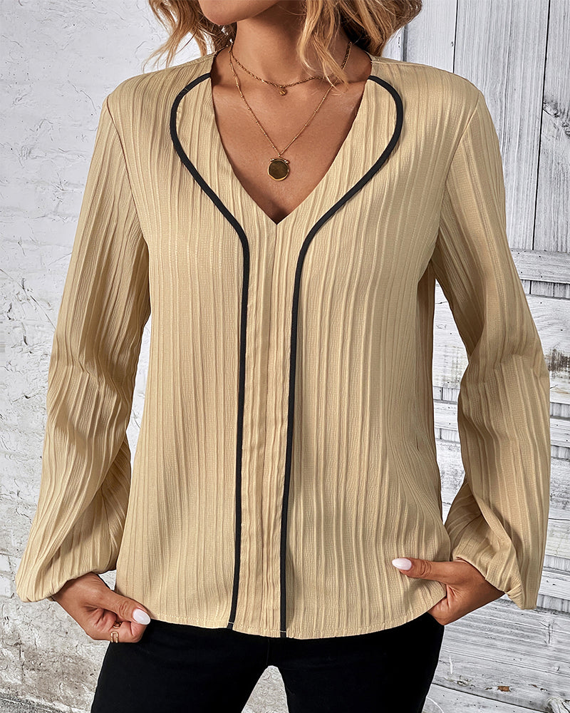 Women's elegant V-neck long sleeve top with chic balloon sleeves. Versatile blouse for office or stylish casual wear.